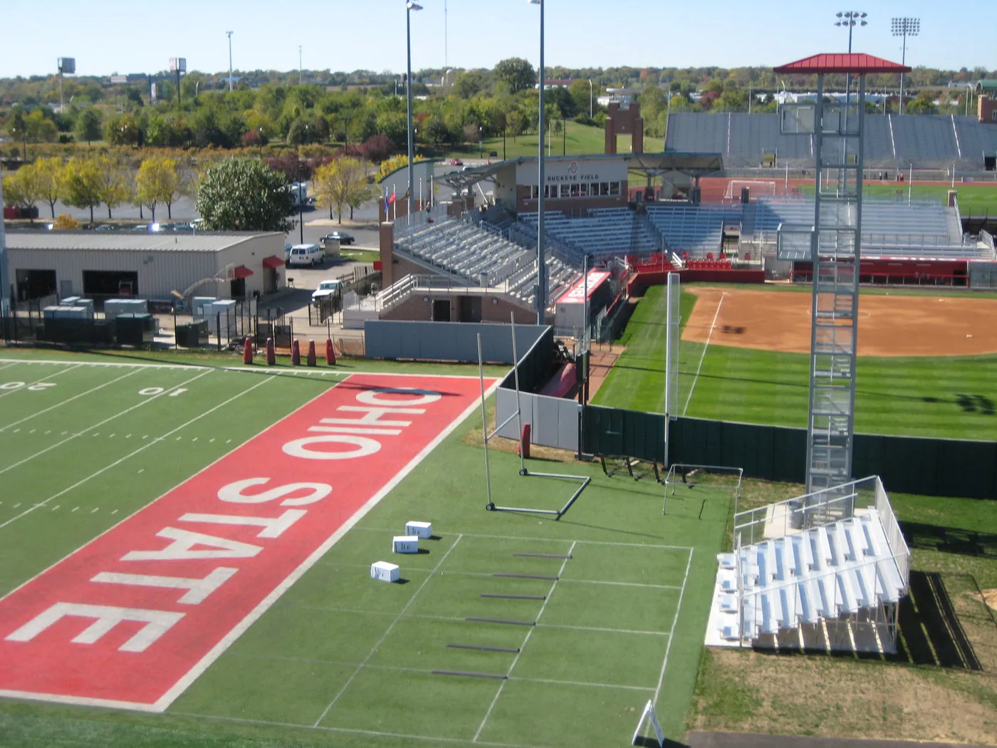 Aerial view of Ohio State University's practice football field and an adjacent baseball diamond, with stadium bleachers and a light tower visible.